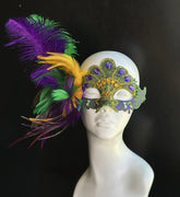 Purple, green, and gold Mardi Gras masquerade mask featuring embroidered lace, sparkling acrylic rhinestones, shimmering sequins, and dramatic faux peacock-inspired feathers. Ideal for Carnival festivals, Mardi Gras celebrations, Venetian masquerade balls, Halloween parties, cosplay conventions, theatrical performances, ballroom galas, costume events, and elegant formal occasions.