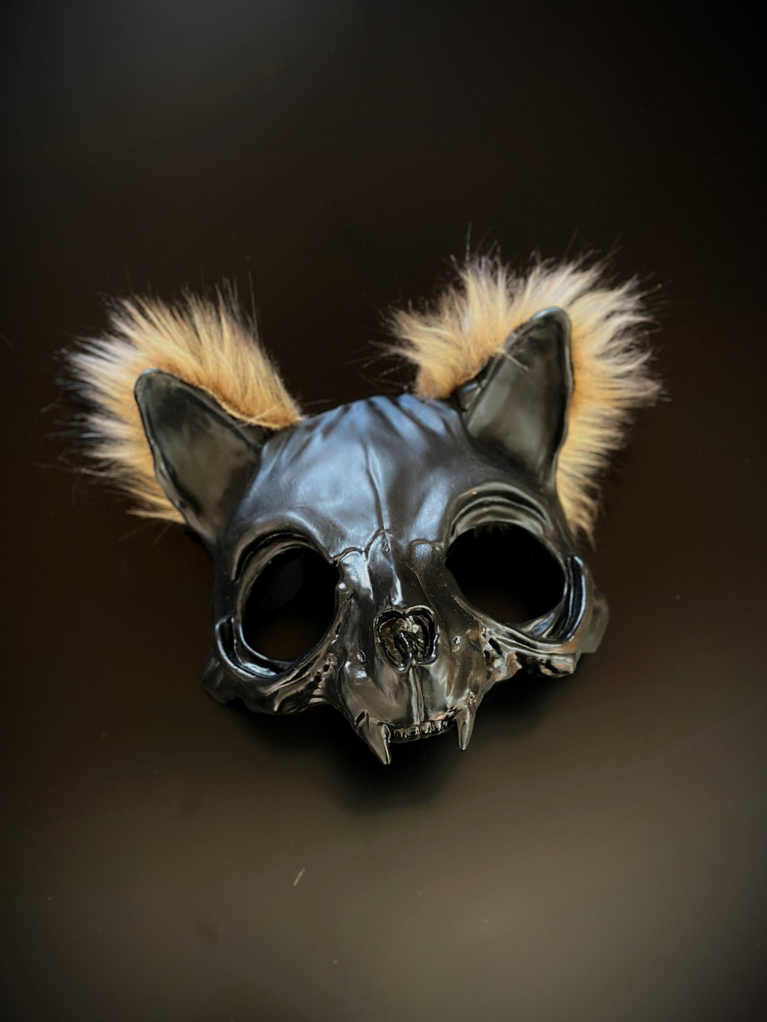 Black cat skull mask with fur tufts, featuring a gothic and eerie design.