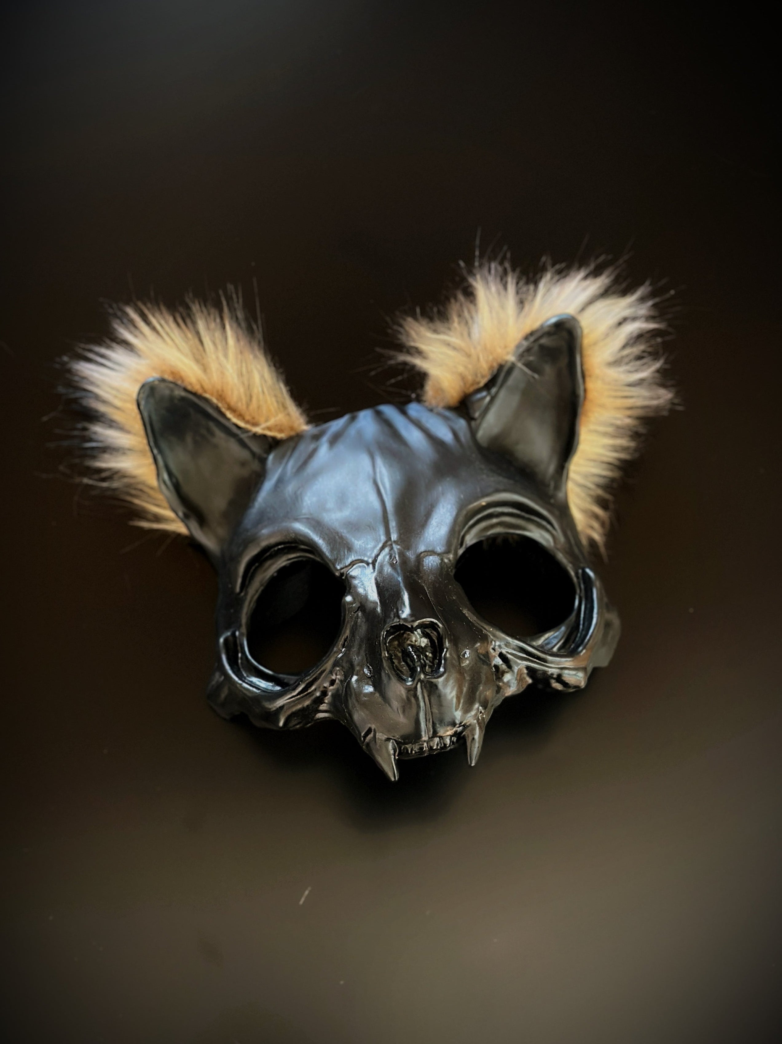 Black cat skull mask with fur tufts, featuring a gothic and eerie design.