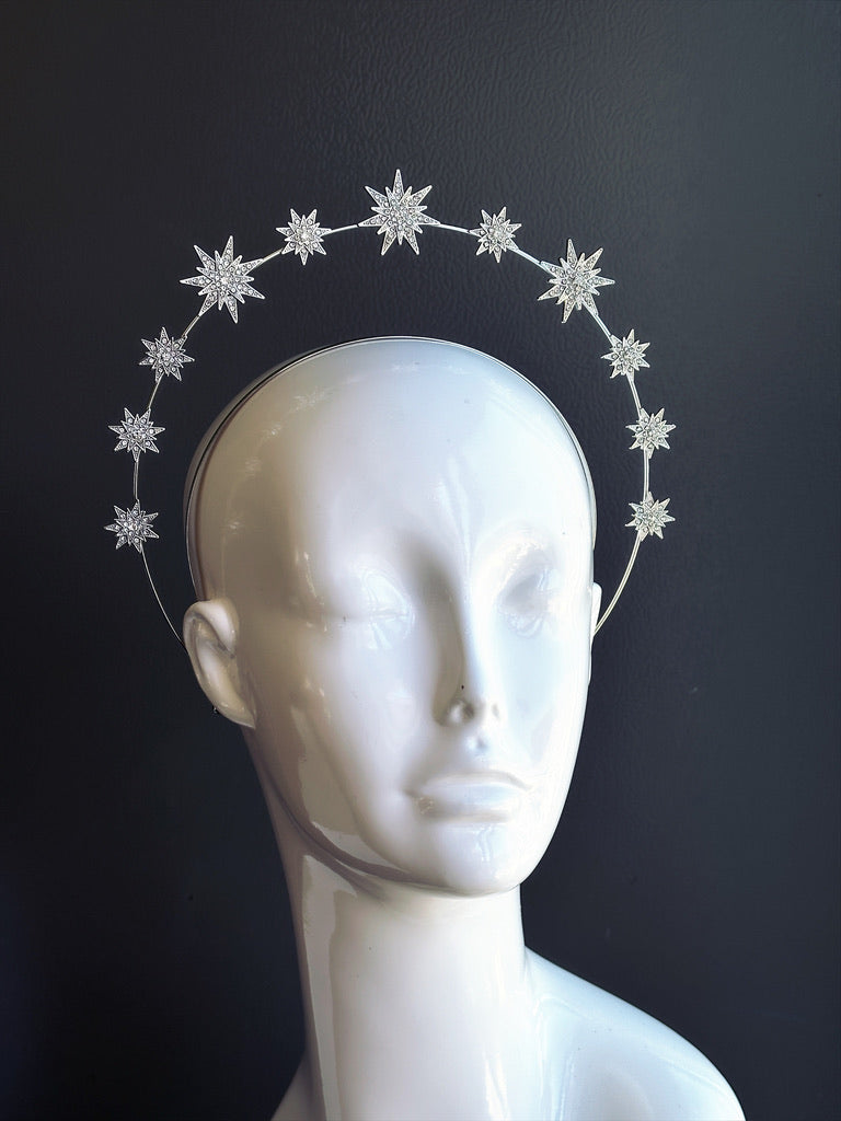 Silver celestial halo headband with crystal starburst embellishments arranged in a circular crown silhouette on mannequin head