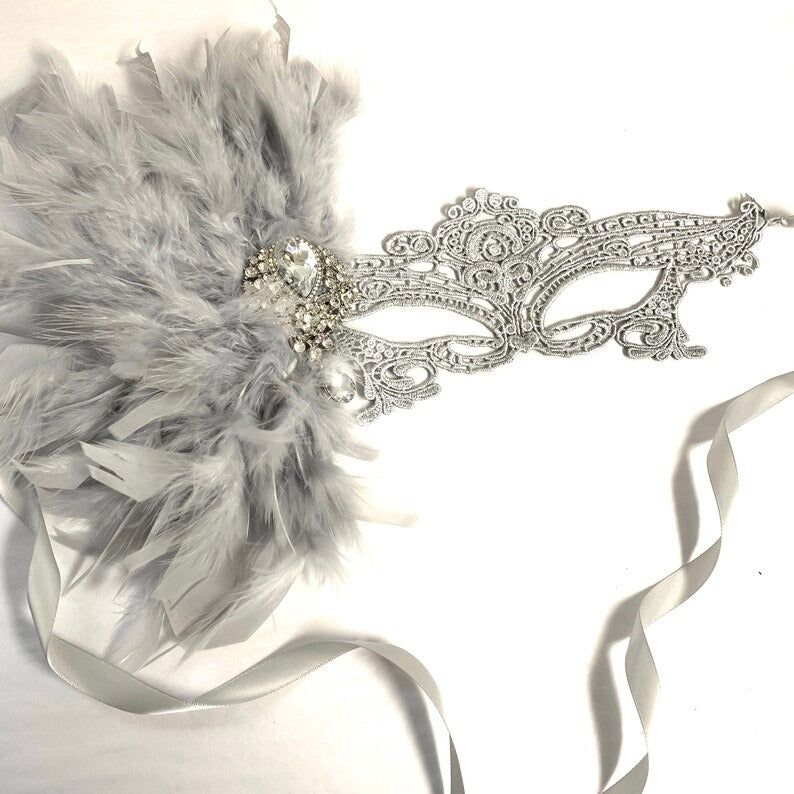 Elegant silver masquerade mask with feathers and rhinestones, Venetian lace design for women’s events and parties.