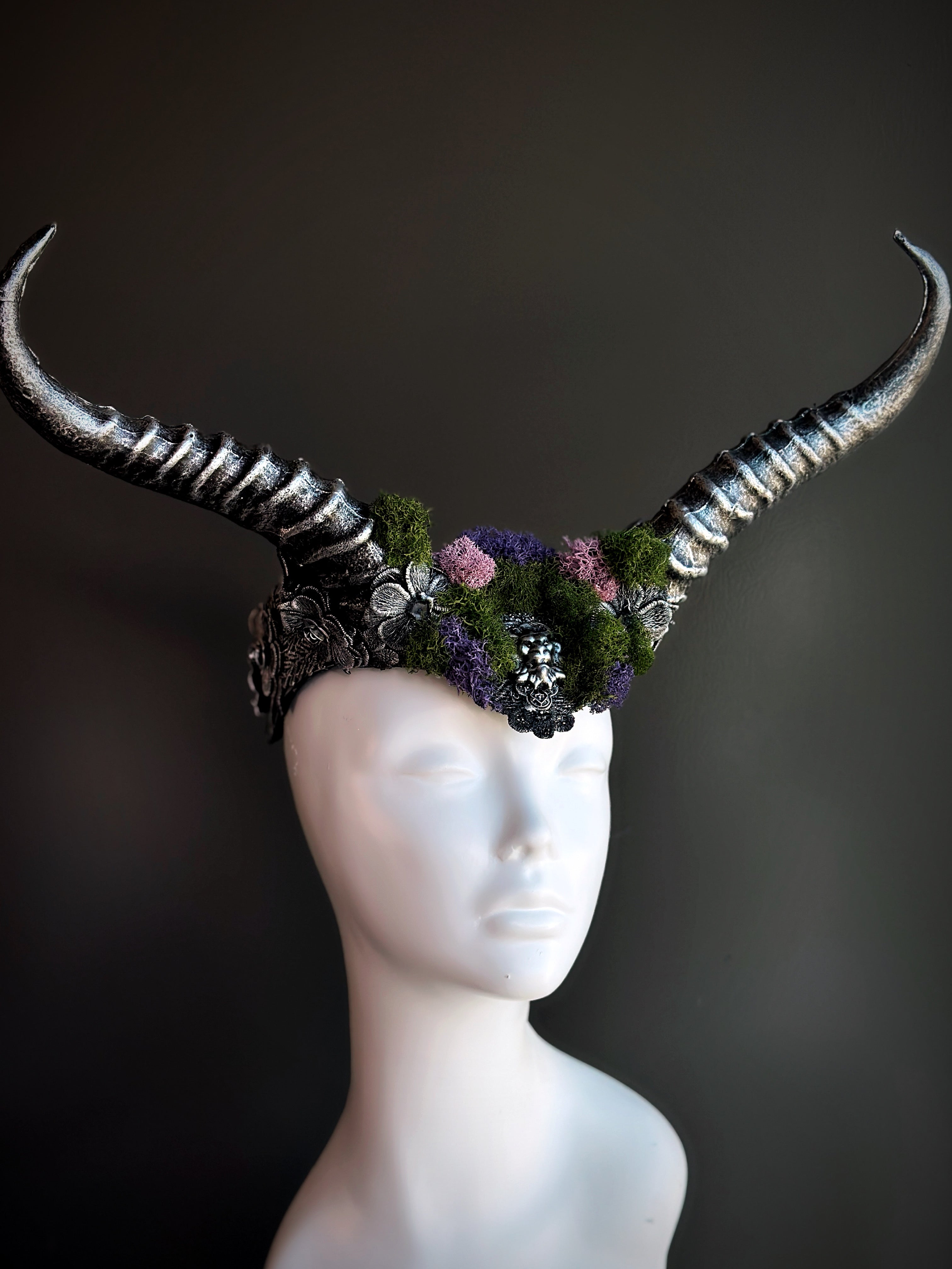 Silver horned headpiece adorned with green and purple moss, perfect for fantasy, gothic, and festival wear.

