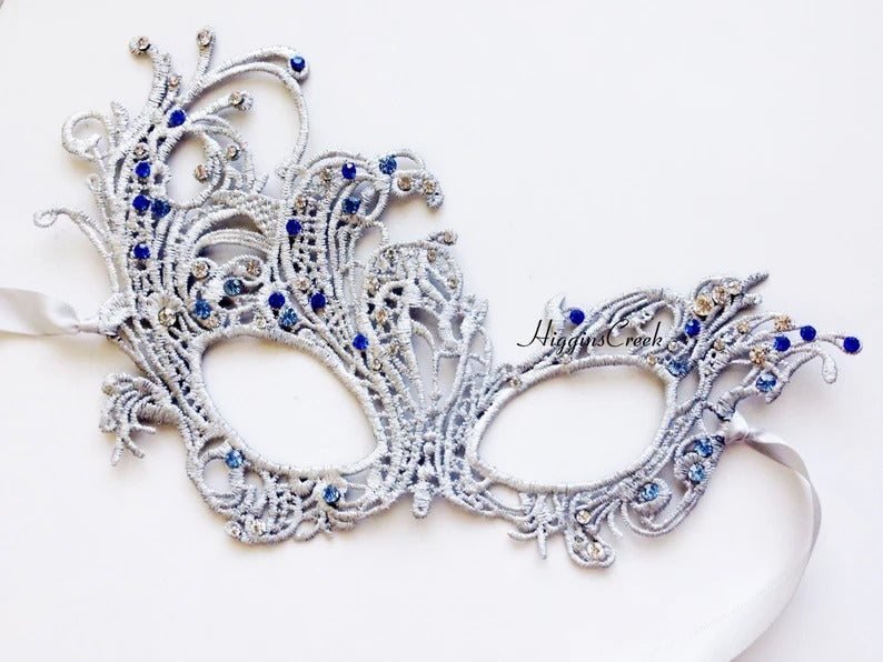 Elegant silver lace masquerade mask with blue rhinestones, ideal for Venetian parties, proms, or weddings.