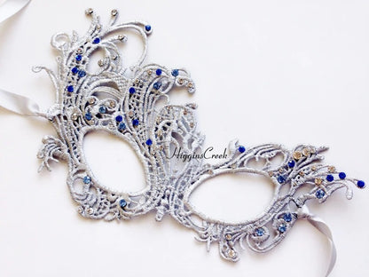 Elegant silver lace masquerade mask with blue rhinestones, ideal for Venetian parties, proms, or weddings.