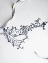 White and silver masquerade mask with phantom 
details for Halloween