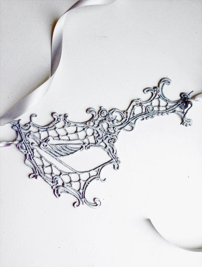 White and silver masquerade mask with phantom 
details for Halloween