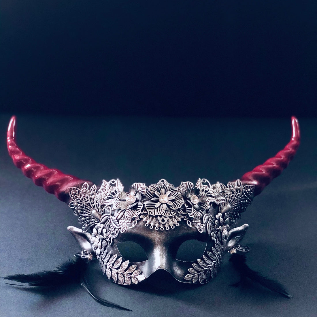 Silver and red gothic floral horn masquerade mask with black feathers