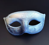 Silver and royal blue Venetian masquerade eye mask with metallic ombre finish, embossed Baroque scrollwork, decorative braided trim, and satin ribbon ties for masquerade balls, Mardi Gras celebrations, gala events, and carnival parties.