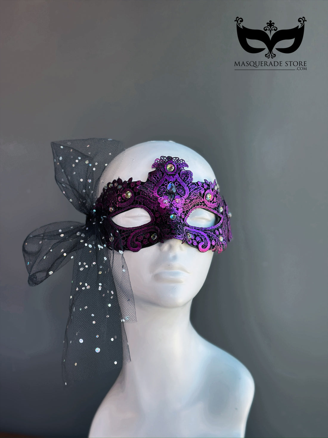 Purple masquerade mask with scroll pattern and rhinestone-studded tulle bow for prom or party