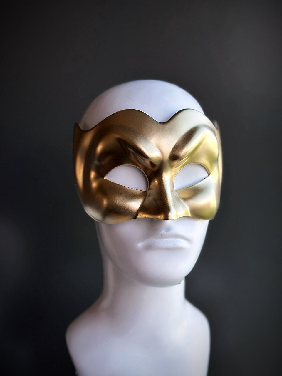 Gold Venetian Devil Mask with a sculpted, dramatic expression displayed on a mannequin.

