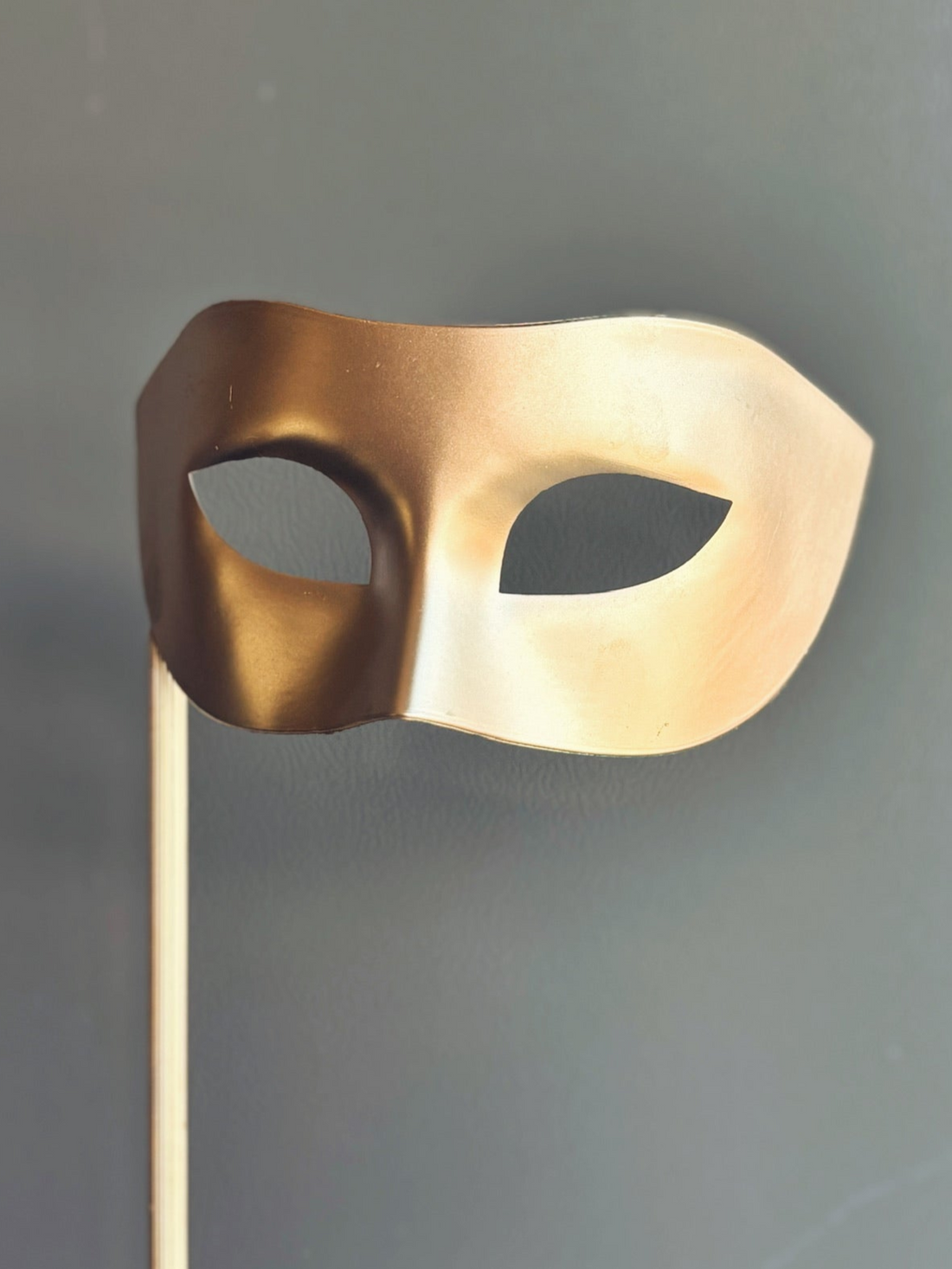 Classic gold Venetian masquerade mask on a stick