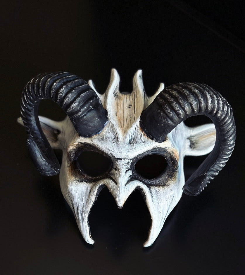 White and black ram horn fantasy masquerade mask with distressed bone-inspired finish, sculpted curved horns, and lightweight polyresin construction for Halloween, cosplay, masquerade balls, gothic events, theatrical performances, and fantasy-themed costumes.