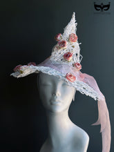 White wire witch hat decorated with pink roses and ribbon for whimsical fairy or Halloween costume looks.