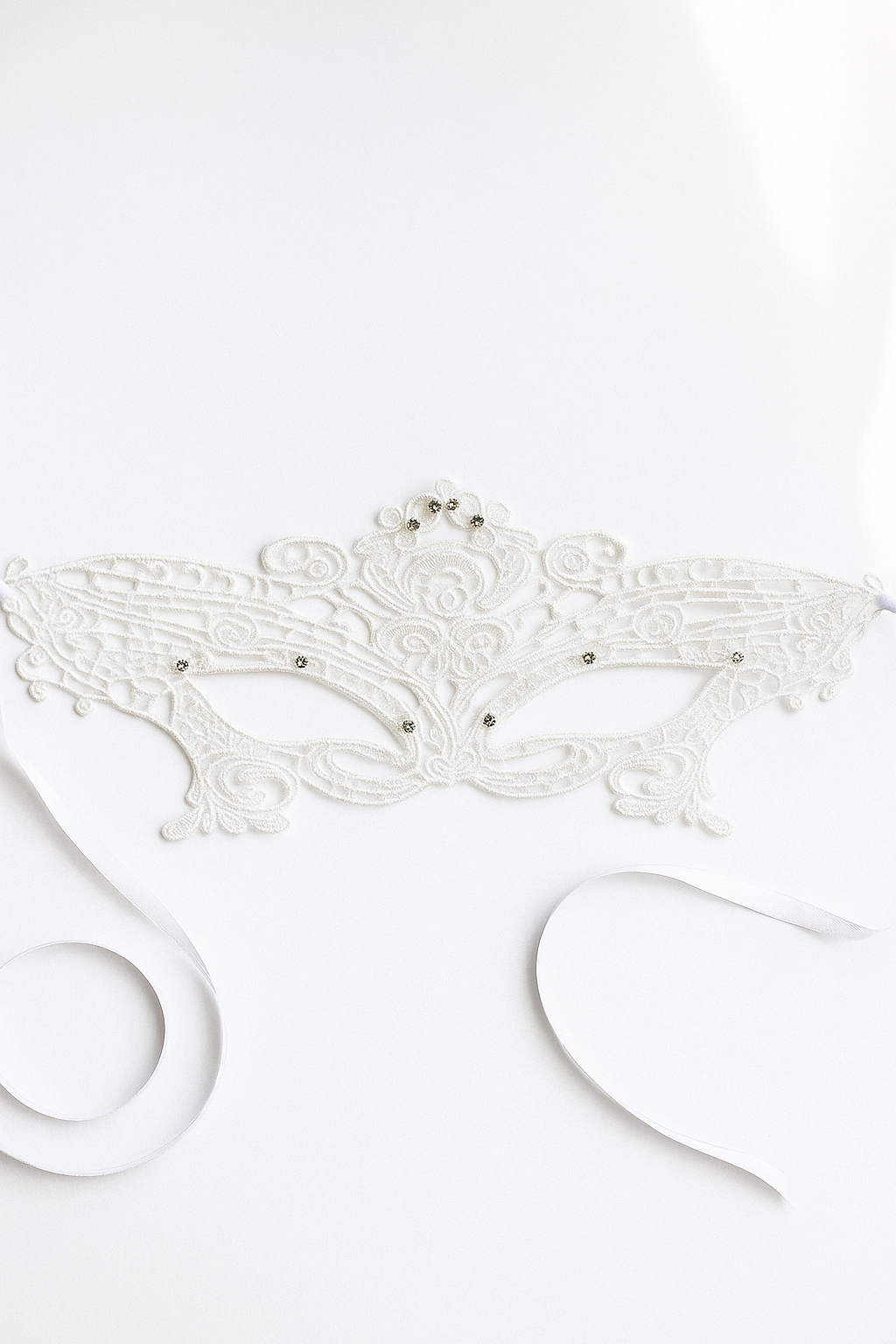 White lace masquerade mask with intricate embroidery, rhinestone details, and satin ribbon ties, ideal for weddings, masquerade balls, prom, and Halloween.
