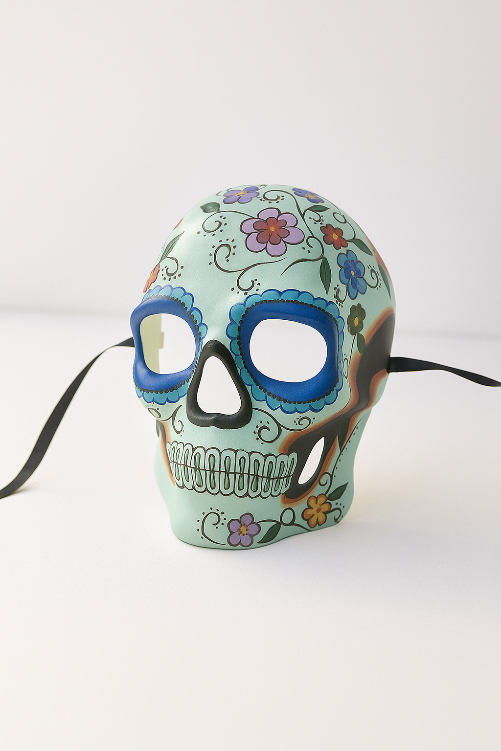 Day of the Dead masquerade mask in white with colorful flowers.