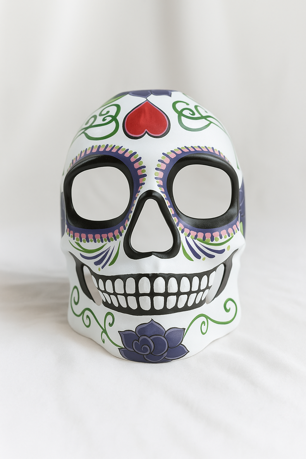 White sugar skull mask with red heart forehead and floral scrolls.