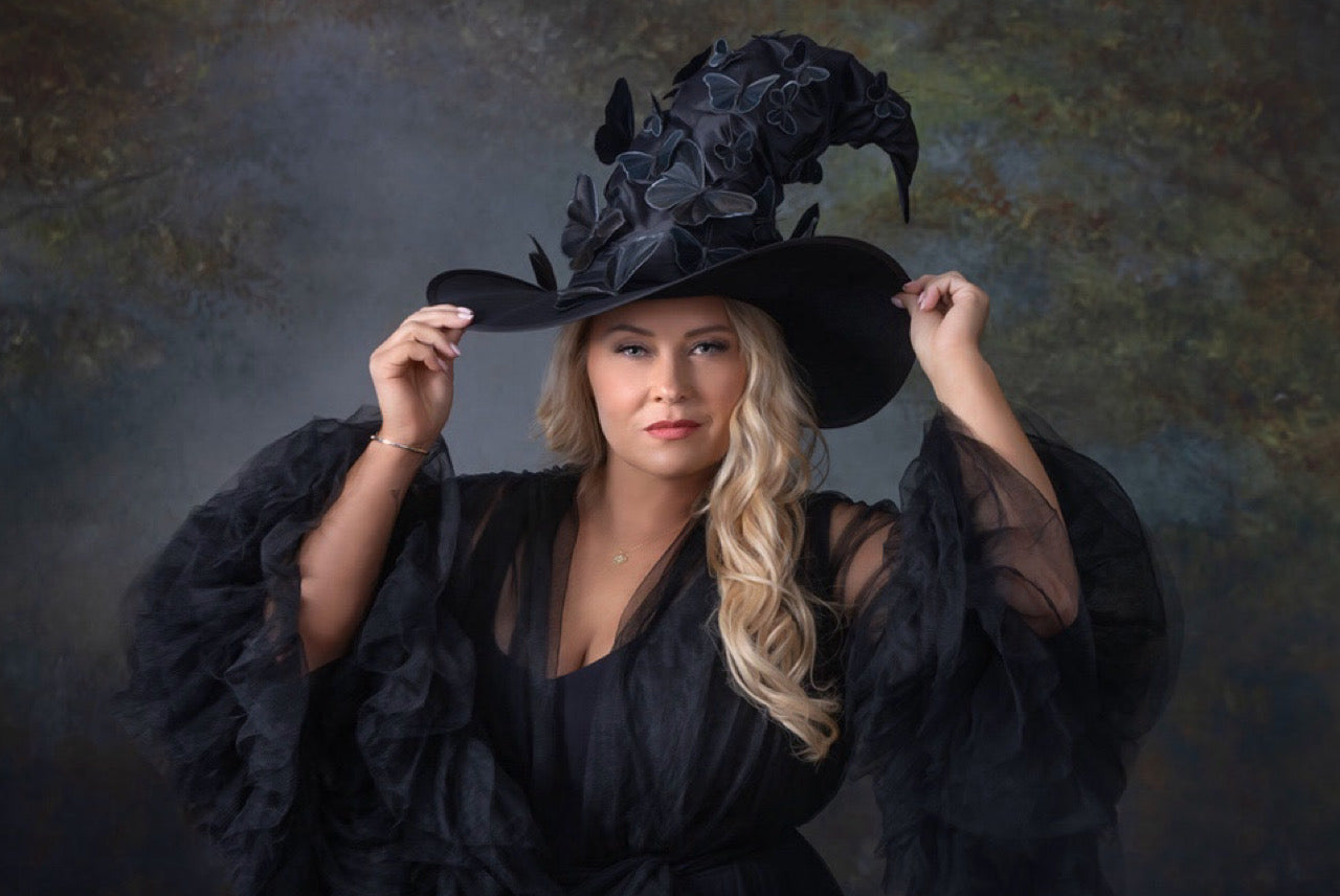 Customer wearing a witch hat adorned with butterflies - masquerade costume accessory