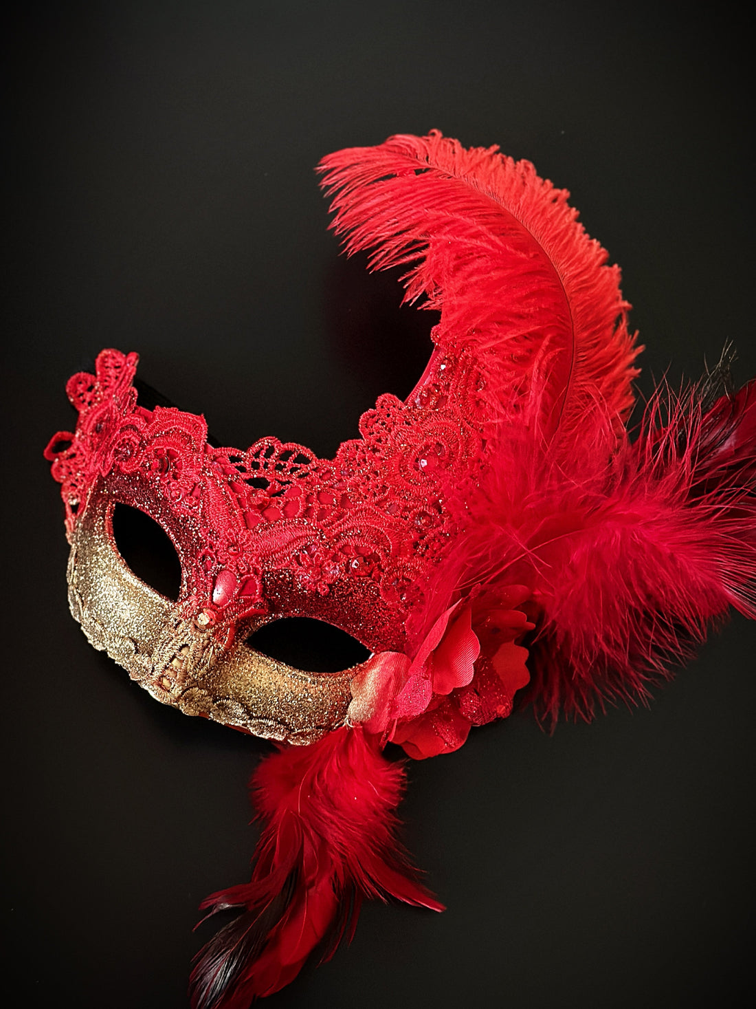 Red gold mask set with feathers and gems.