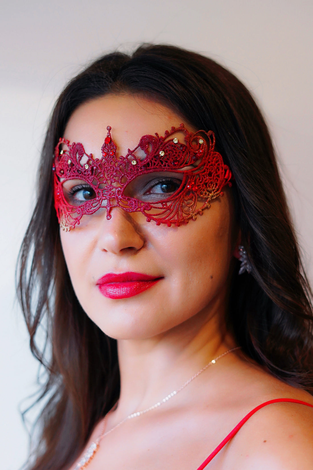 Red lace masquerade mask with gold and red rhinestones.