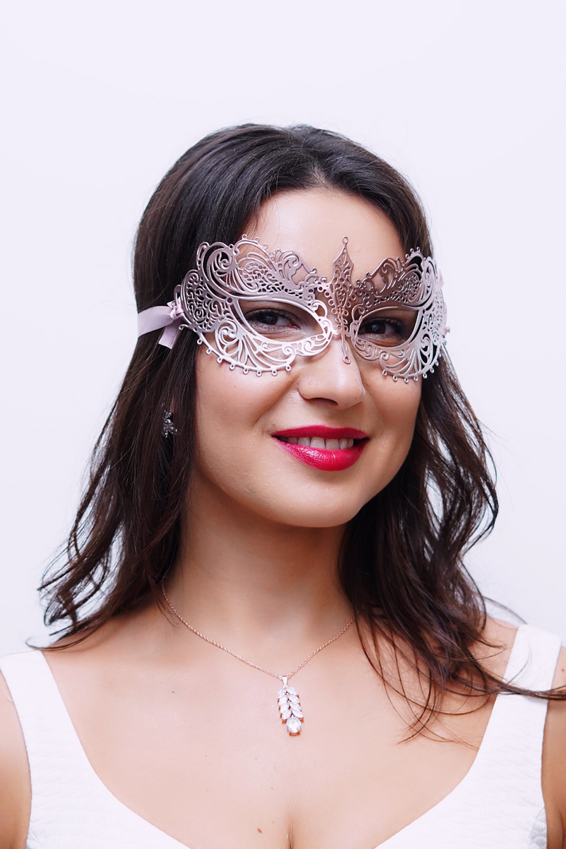 Rose gold metal masquerade mask with matching rose gold satin ribbons.