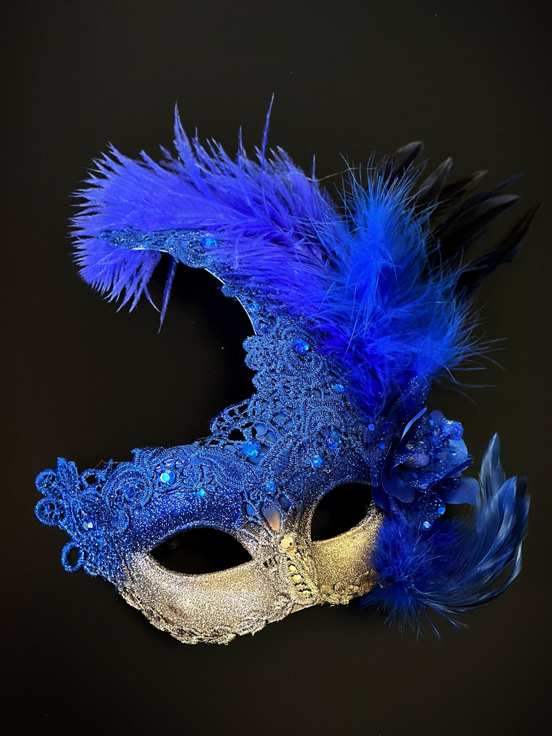 Blue and gold feather masquerade mask with lace, gems, and glitter.