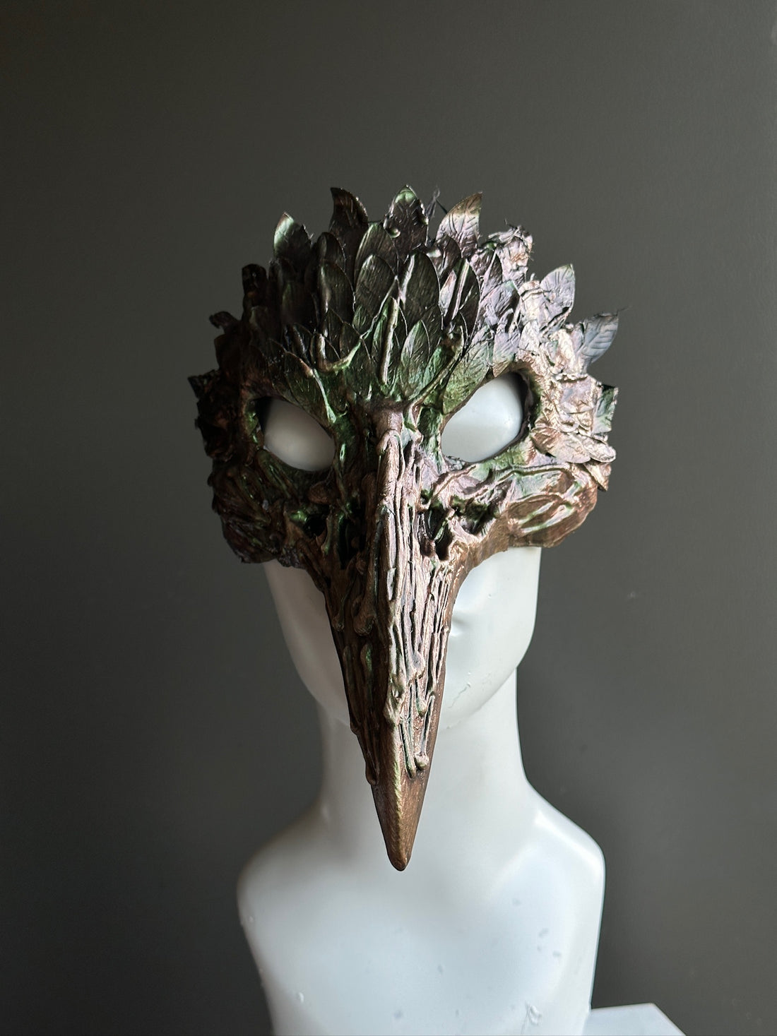 Woodland plague crow masquerade mask with beak design, green and bronze leaf texture, fantasy gothic costume accessory