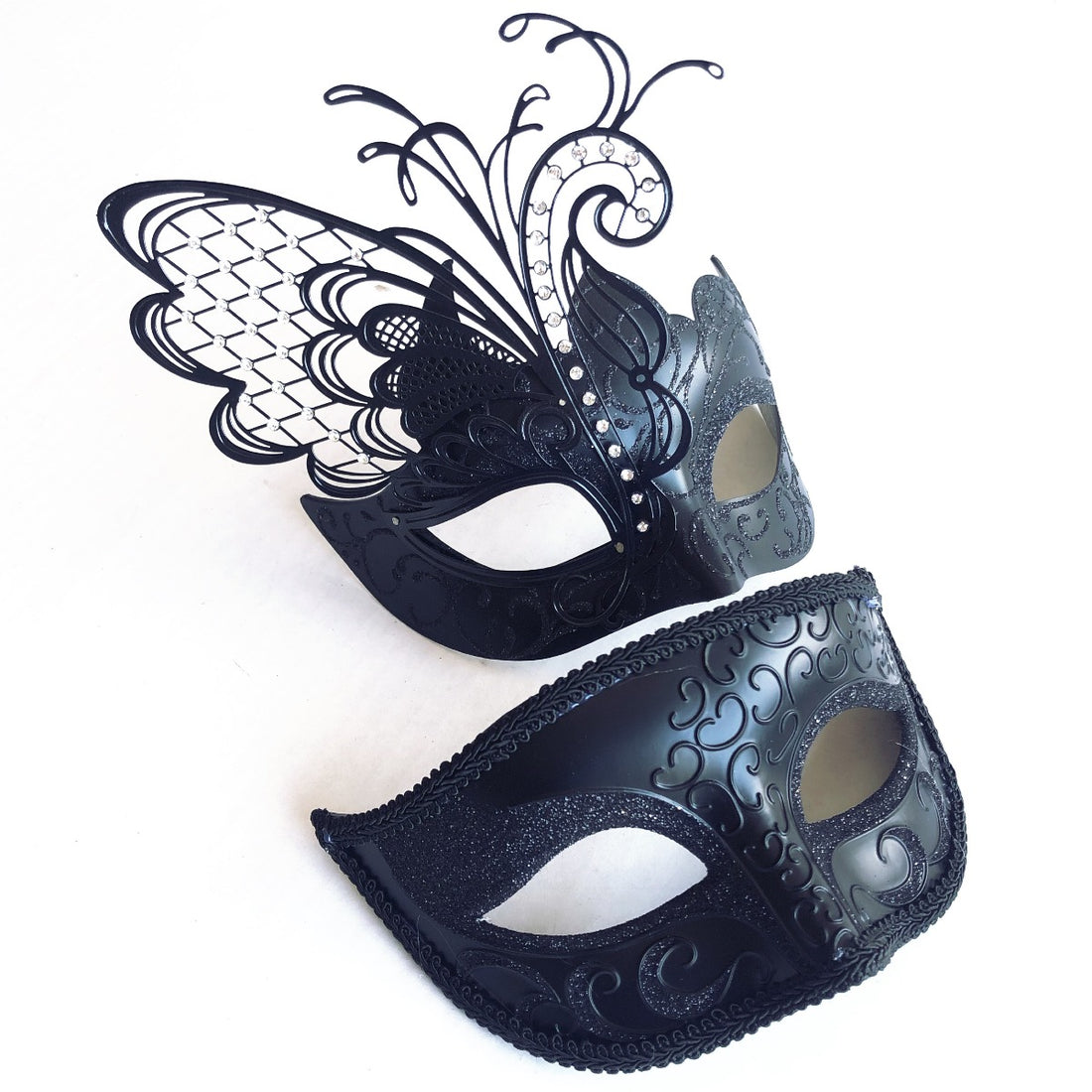Elegant black Venetian couples masquerade masks featuring a butterfly wing design for women and a scroll-patterned mask for men, perfect for formal events and themed parties.

