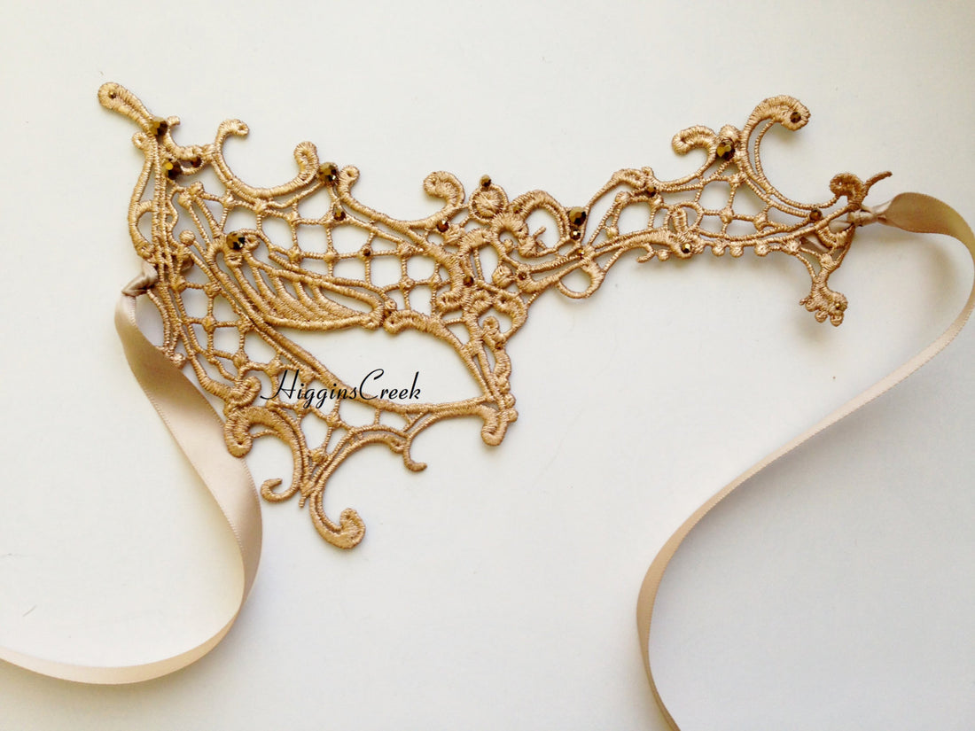 Elegant gold filigree mask with airy scrolls and romantic lace ribbon tie
