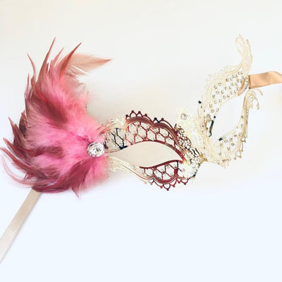 Women's masquerade mask in gold with rhinestones and candy pink feathers with a crystal gem.